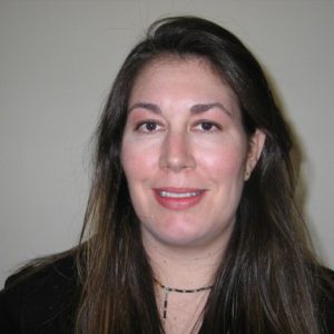 A photo of a smiling woman wearing a black blouse.