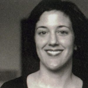 A black and white photo of a woman smiling.