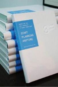 A photo of a few stashed books, with the covered colored blue and white, also having an engraving.