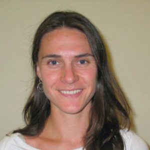 A photo of a smiling woman wearing a white shirt.