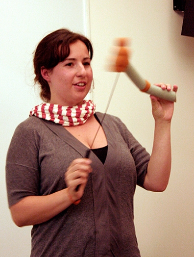 A woman holding a gray and orange stick vibrating.