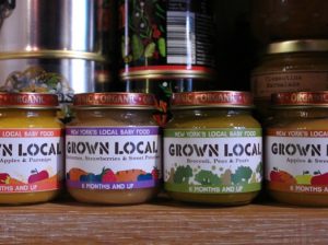 A photo of some covered jars with different design labels. The text on the label: Grown Local.