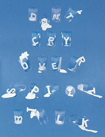 An image showing glass cups containing some white shaped letters made from a substance that is spilling.