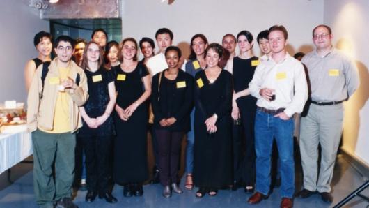 A photo of a group of people siting and wearing some yellow labels.