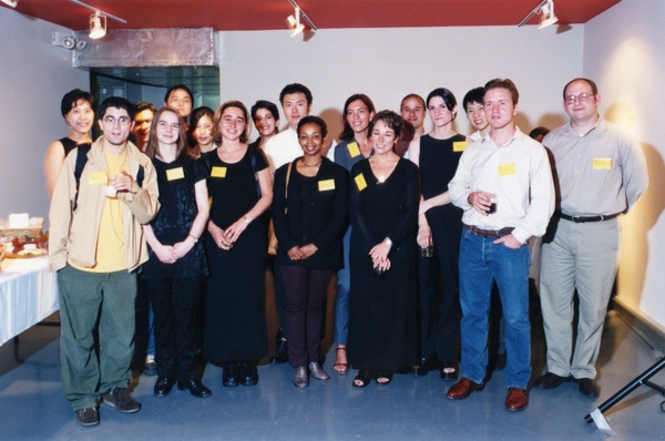 A photo of a group of people siting and wearing some yellow labels.