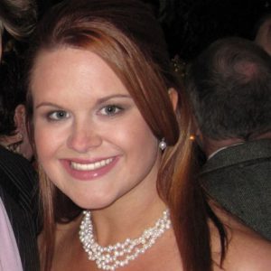 A photo of a woman wearing a white pearl necklace.