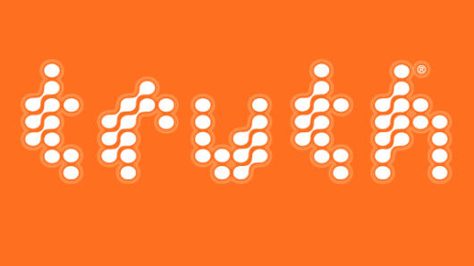 An orange poster that has letters made from connected white dots.