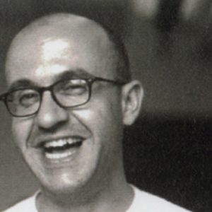 A black and white photo of a man wearing glasses.