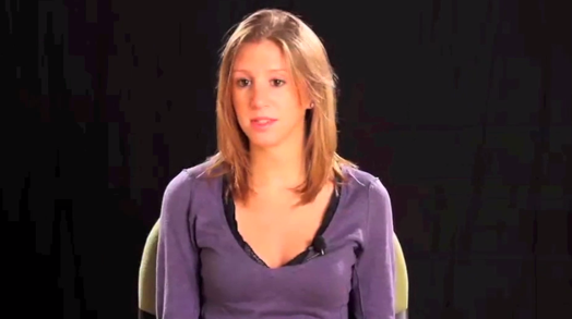 A photo of a woman wearing a purple blouse on a black background.