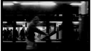 A black and white photo of people in a subway station.