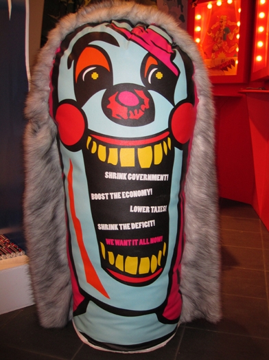 A photo of clown head made from some textile fabric and around it a fur coat.