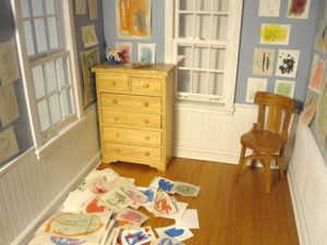A photo of a room with a cabinet, a chair and some papers spread all over the place.