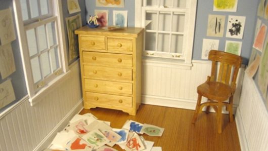 A photo of a room with a cabinet, a chair and some papers spread all over the place.