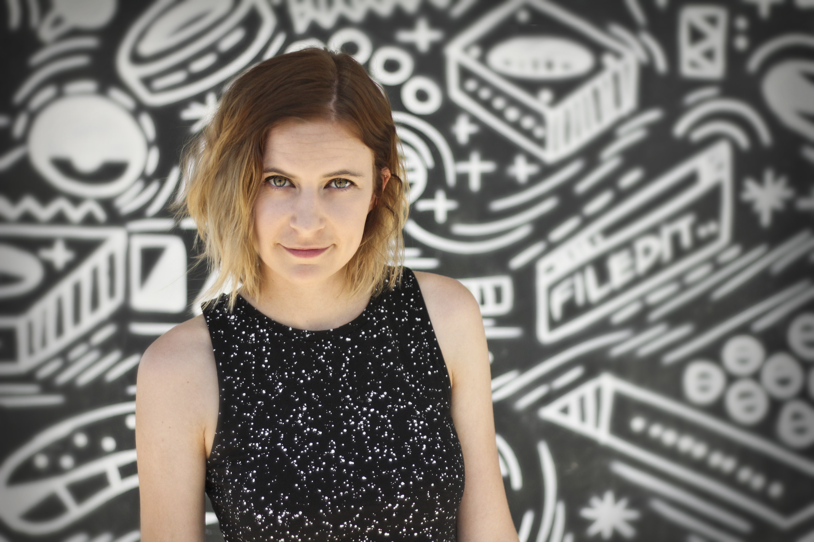 A photo of a woman dressed in a black dress with white spots on it.