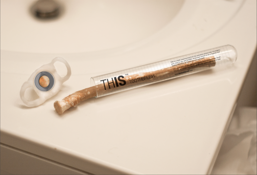 A photo showing a transparent plastic tube with a whiten cap. The tube contains a piece of stick and it's placed on a sink.