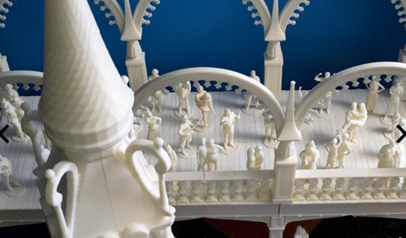 A photo of some white 3d print showing a castle tower and a bridge filled with figurines looking like people.