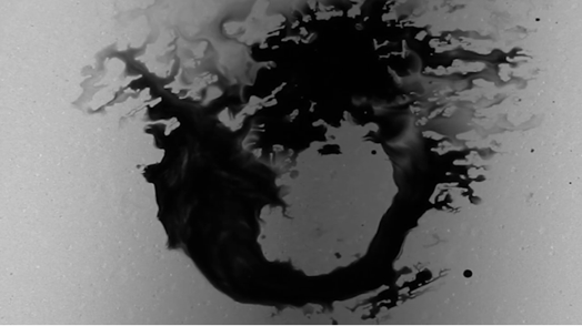 A black and white photo of some liquid mixing with another.