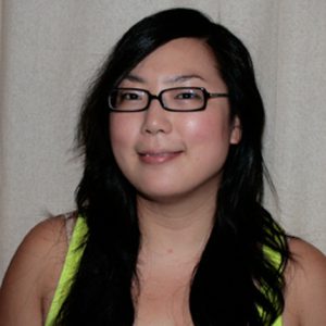 A photo of a woman wearing glasses and a green undershirt.