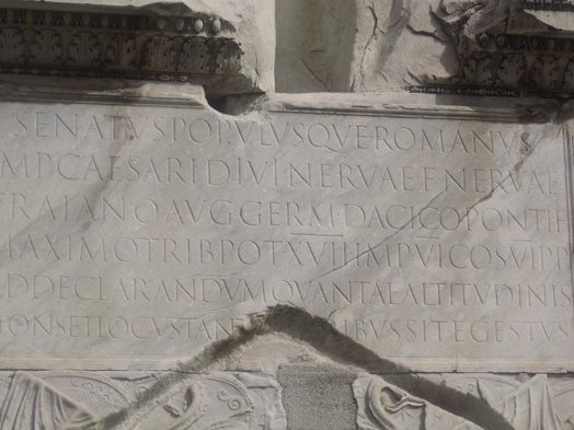 A photo of a stone engraved with letters in Latin language.