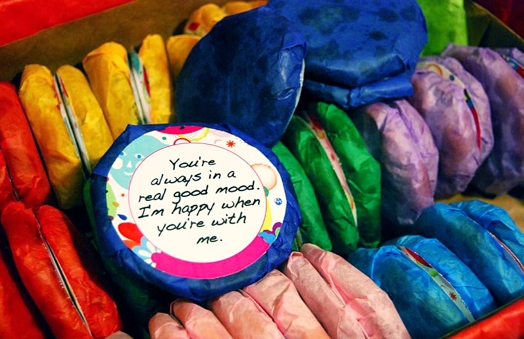 A photo of macarons made from blue, red, green yellow, pink and purple paper. On one of them is the text: You're always in a good mood. I'm happy when you're with me.