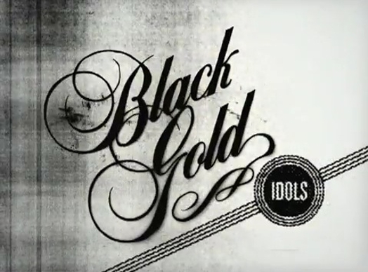 A black and white print with stylized words Black Gold and Idols in a circle and a line under.