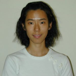 A photo of a smiling woman wearing a white blouse.