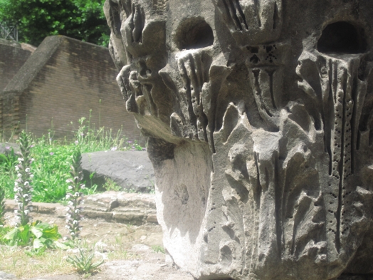 A photo of a stone pillar engraved with with different floral patterns.