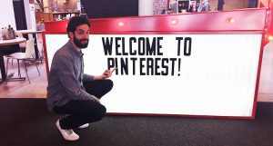 A photo of a man crouched near a white counter table. On the side of the table is a text that says: Welcome To Pinterest! .