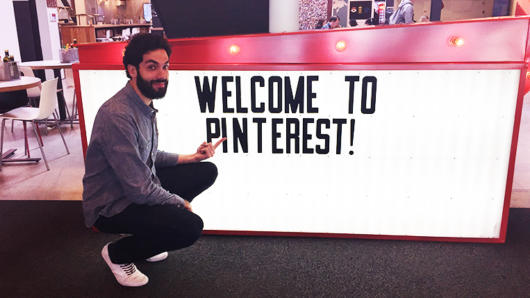 A photo of a man crouched near a white counter table. On the side of the table is a text that says: Welcome To Pinterest! .