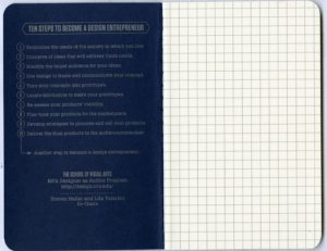 A blue notebook with text on a side and squares on the other.