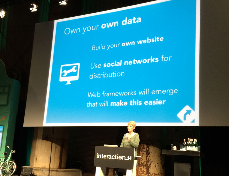 A photo of a person giving a lecture on a stage and showing a text on a projector screen. The text says: Own your own data. Build Your own website. Use social networks for distribution. Web frameworks will emerge that will make this easier.