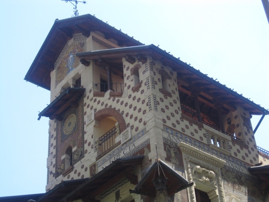 A photo of a house with mosaics and white and brown squares on its walls.