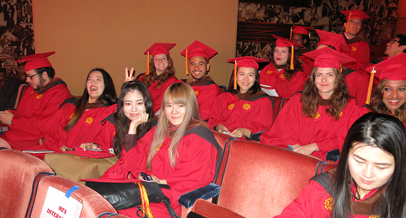 A photo of a group of grad students wearing robes and hats from the School Of Visual Arts.
