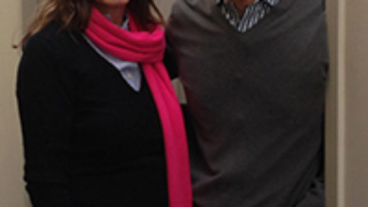 A photo of a man and a woman wearing a red scarf.