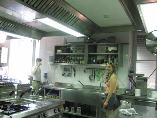 A photo of a man and a woman sitting in a restaurant kitchen.
