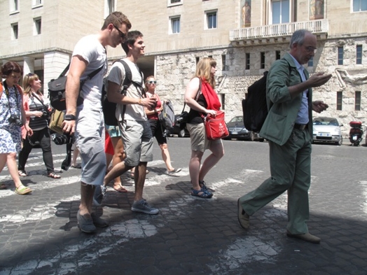 A group of people walking on a crosswalk.