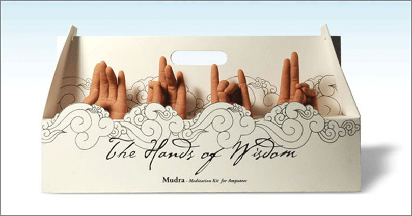 A white cupcake box in which there are four hands with different gestures. On the box there is a text which says: The Hands of Wisdom.