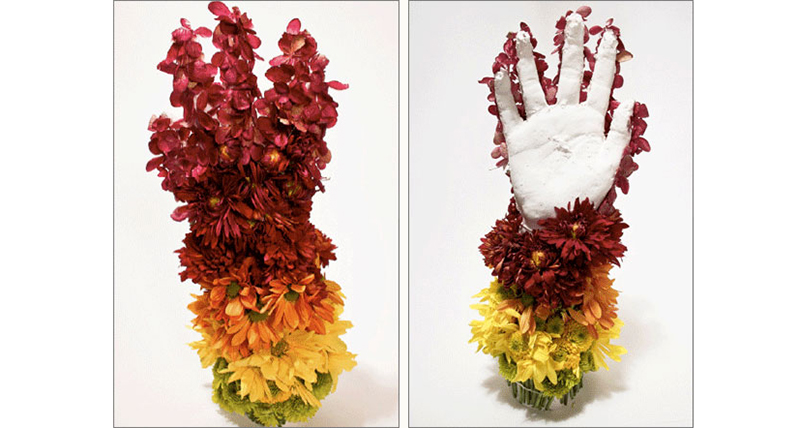 An artistic representation of a white hand and around it there are some green, yellow, orange and red flowers put in gradient style.