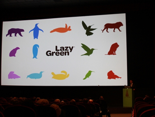 A photo of a screen projection showing colorful icons depicting animals and the text Lazy Green in the middle.