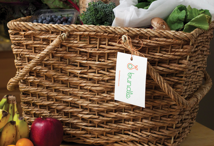 A picnic basket filled with vegetables and a label attached to it on which there is a bag logo and the text: bundle.