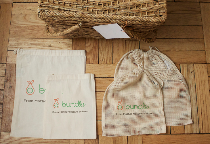 A photo of a picnic basket and some tissue bags stamped with a branding logo that depicts a bag and the word: bundle.