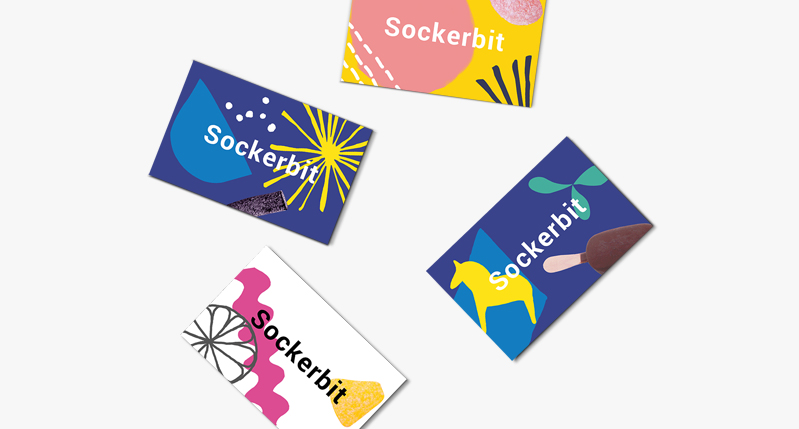 A set of colorful cards with animal, plants and food pictograms on them. There is also a text: Sockerbit.