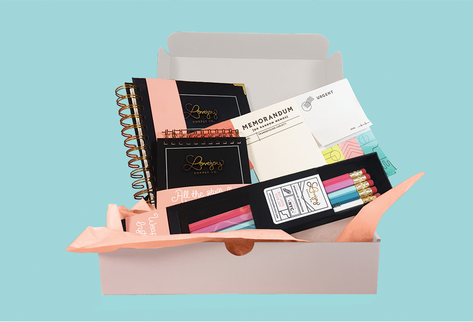 A computer generated image of a card box containing notebooks, colored crayons boxes, sticky notes and other office items.