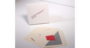 A set of white cards with grey, black and white shapes on them.