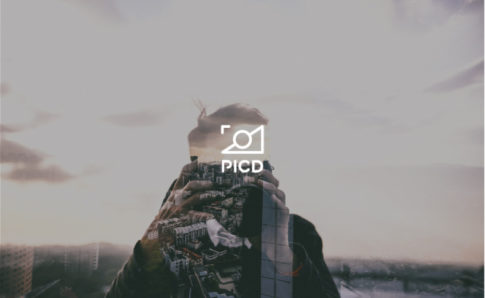 A photo of what seems like a peak with different buildings on it and the text logo PICD.