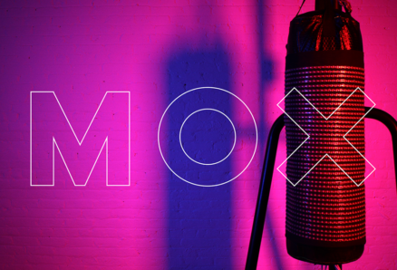 A photo of a punching bag with blue and pink LED's on it and the text MOX over it.