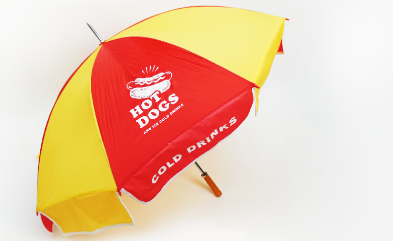 a red and yellow umbrella with hot dogs logo on it