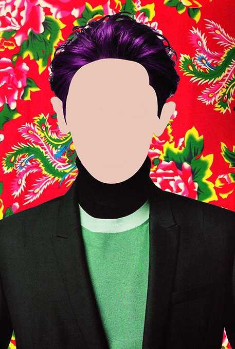 An image depicting a faceless human figure with purple hair, wearing a green blouse and a tuxedo. There is a colorful red, green, blue and yellow background depicting fractal shapes.