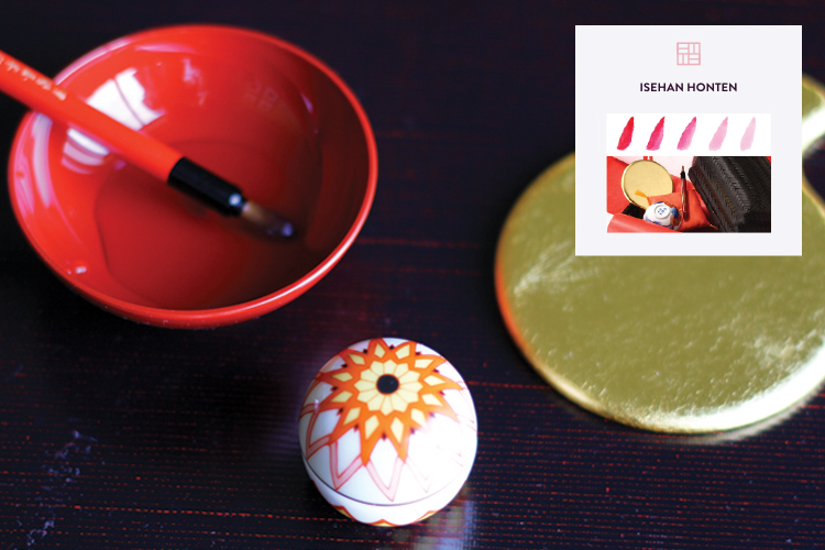 A photo of a red, a pencil, some egg shaped object with drawing on it and some golden paint blob on a table with some label on it.
