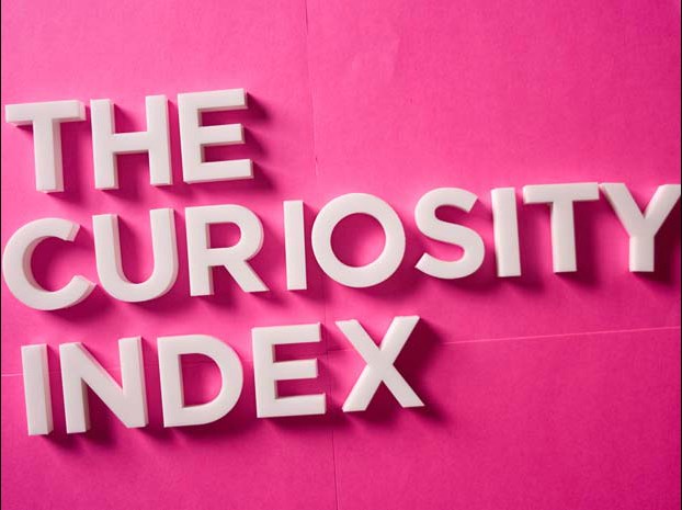 A 3d text on a pink surface. The text says: The Curiosity Index.